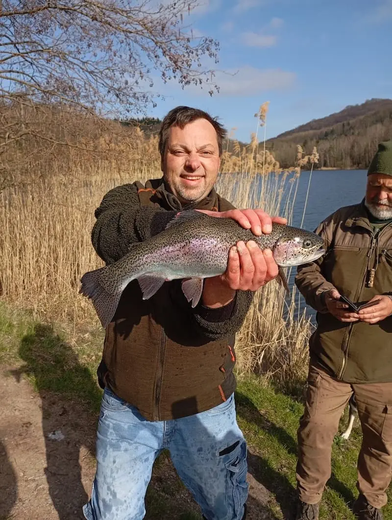 Christian Forelle Fischbesatz Mann mit Forelle glücklich